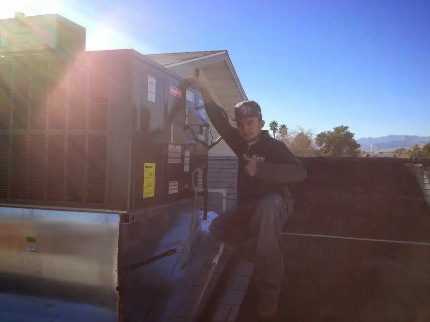 HVAC technician performing Air Duct Repair on a rooftop unit in Napili-Honokowai